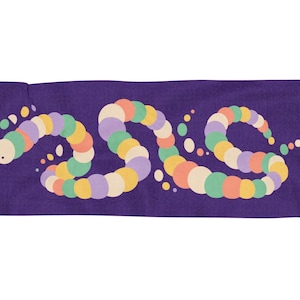 May include: A rectangular purple towel featuring a long, winding caterpillar graphic composed of multicolored circular segments in shades of yellow, orange, green, and light purple, with small matching dots scattered around the body.