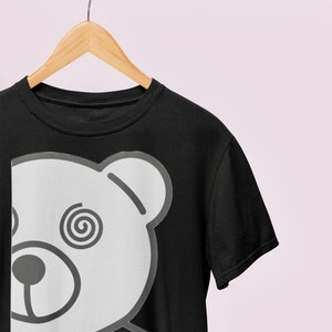 May include: A black t-shirt with a white graphic of a bear's face with a spiral design in its eye.