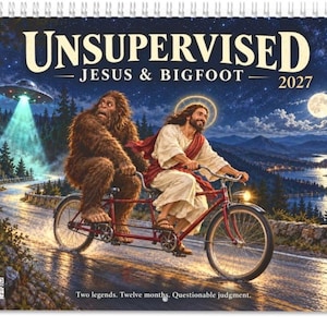 May include: A 2027 wall calendar titled UNSUPERVISED JESUS & BIGFOOT featuring an illustration of Jesus and Bigfoot riding a red tandem bicycle on a road at night. A UFO shines a light nearby under a starry sky with a full moon and lake landscape.