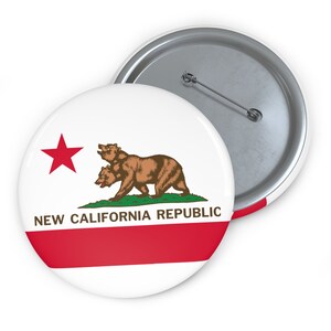 May include: A white button with a red star, a brown bear with three heads, and the text "NEW CALIFORNIA REPUBLIC" in red and black letters. The button has a silver back.