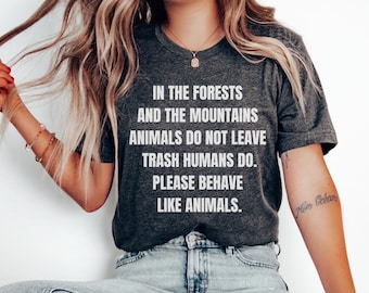 May include: A dark gray t-shirt with white text that reads "In the forests and the mountains animals do not leave trash humans do. Please behave like animals."