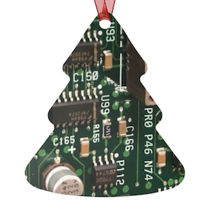 May include: A green Christmas tree ornament shaped like a circuit board with text that reads "PRO P46 N74" and "C166 P112".