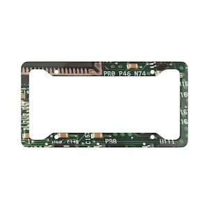 Puede incluir: Marco rectangular para matrícula con diseño de placa de circuito verde. El marco tiene un borde negro e incluye texto como "PRO P46 N74". Diseñado para una matrícula estándar.