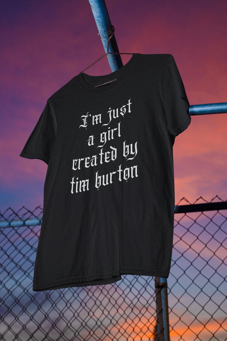May include: Black t-shirt with white text in a gothic font that reads "I'm just a girl created by Tim Burton".