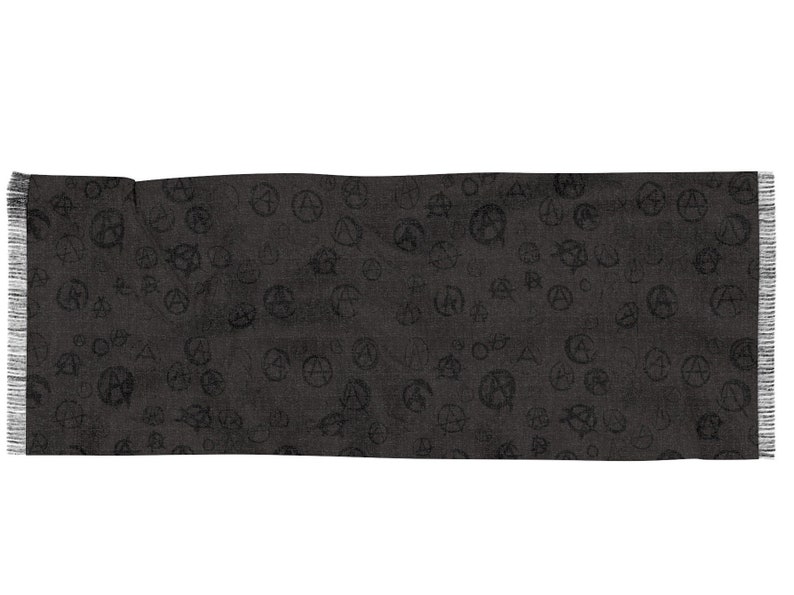May include: A black scarf with a repeating pattern of anarchy symbols. The scarf has a fringed edge.