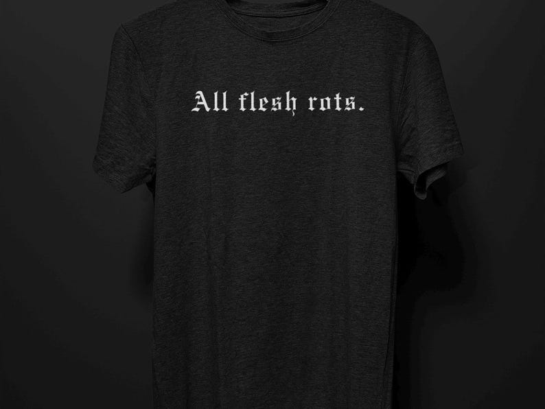 K&ouml;nnte beinhalten: Dunkelgraues T-Shirt mit dem wei&szlig;en Schriftzug "All flesh rots" in gotischer Schrift. Das Shirt hat einen Rundhalsausschnitt und kurze &Auml;rmel. Der Hintergrund ist einfarbig schwarz.