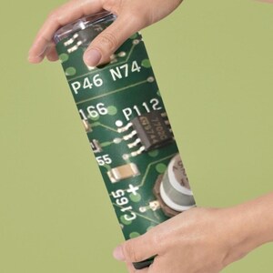 May include: A green and black insulated tumbler with a circuit board design. The tumbler features the text "P46 N74" and "P112".