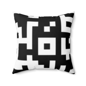 May include: Black and white throw pillow with a geometric pattern resembling a QR code.