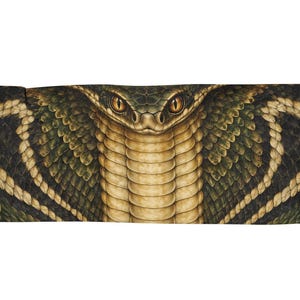 Puede incluir: Una manta rectangular tejida que presenta un estampado gráfico detallado y simétrico de la cabeza y el cuello de una cobra. El diseño muestra tonos verde oscuro, marrón y bronceado con un patrón de escamas texturizado y ojos amarillos penetrantes.