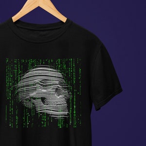 Peut inclure: T-shirt noir avec un motif de crâne blanc qui semble être fait de code numérique. Le crâne est entouré de code vert.