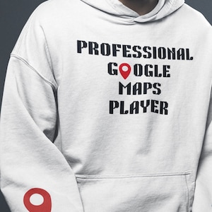 May include: A white hoodie with the text "PROFESSIONAL GOOGLE MAPS PLAYER" in black pixelated font. A red location pin icon is on the left sleeve.