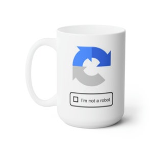 May include: White ceramic mug with a blue and gray "I'm not a robot" reCAPTCHA icon and text.