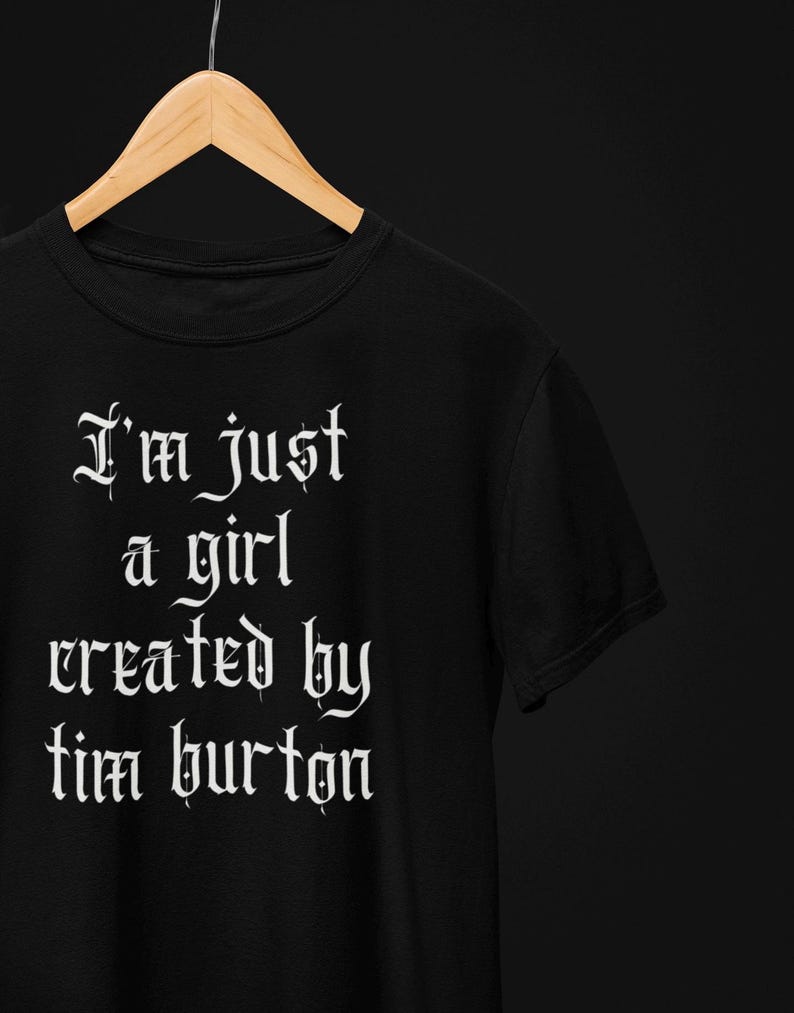 May include: Black t-shirt with white text in a gothic font that reads "I'm just a girl created by tim burton".