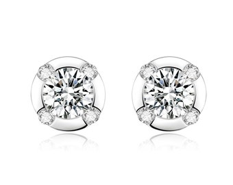 May include: A pair of silver stud earrings with a round, clear center stone surrounded by four smaller clear stones.