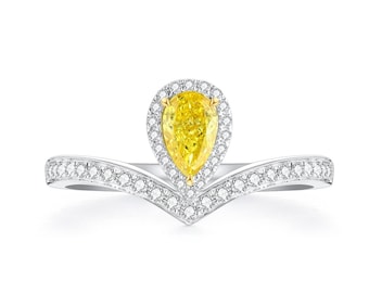 May include: A pear-shaped yellow diamond ring with a halo of smaller diamonds. The ring band is a delicate V-shape with pave diamonds.