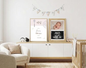 May include: A nursery scene featuring a white cabinet with a wooden top, holding framed artwork. One frame displays a baby's photo and ultrasound image. Another frame has Korean text and the words "Yuna's 100 days". A banner hangs above.