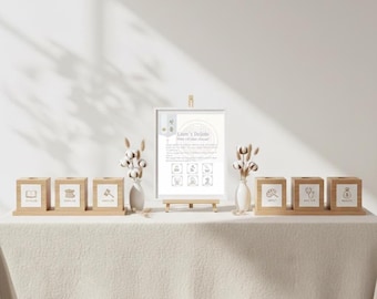 May include: A display of wooden blocks and a framed sign on a table. The blocks feature various icons, and the sign has text that reads "Liam's Doljabi". Decorative elements include vases with cotton stems.