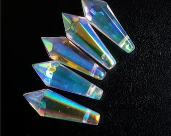 Peut inclure: Cinq pendentifs en cristal iridescent en forme de larme avec une pointe pointue. Les cristaux sont transparents avec un reflet arc-en-ciel.