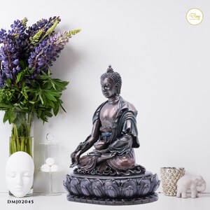 May include: A meditating Buddha statue with a bronze finish, sitting on a lotus base with purple and gray accents. The statue is in a seated position with hands in a mudra gesture.