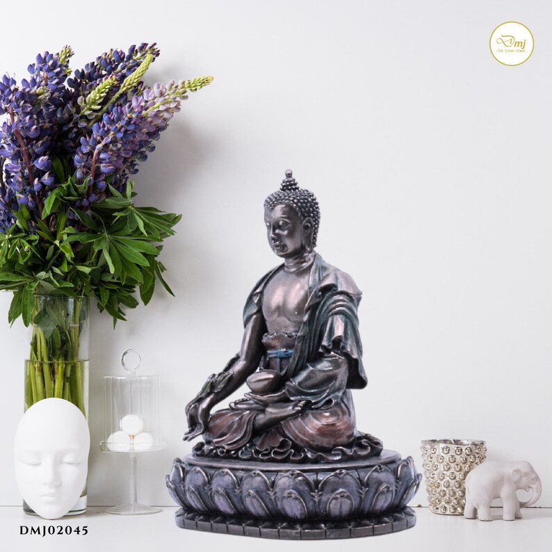 May include: A meditating Buddha statue with a bronze finish, sitting on a lotus base with purple and gray accents. The statue is in a seated position with hands in a mudra gesture.