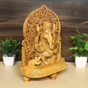 premium wooden religious statue, classic Hindu gift, worship decor item, traditional puja essentials, wooden figurine for spirituality, Indian spiritual gift, rustic pooja decor, handcrafted festival showpiece, antique style Hindu idol, wooden statue for prayer, artistic wooden murti, spiritual home accessory, wooden carving religious idol, small ganesha idol for temple, handmade pooja gift, Lord Ganpati wooden murti, wooden home temple decor