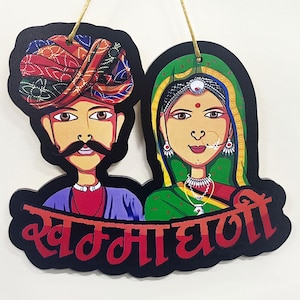 Pode incluir: Uma placa de madeira com fundo preto e texto vermelho que diz "Swami Dhali." A placa apresenta uma ilustração pintada de um casal com roupas tradicionais indianas. O homem está usando um turbante azul e roxo e a mulher está usando um sari verde.