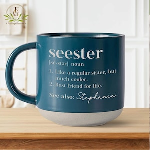 May include: Teal ceramic mug with a white inscription that reads "seester [sé-stər] noun 1. Like a regular sister, but much cooler. 2. Best friend for life. See also: Stephanie"