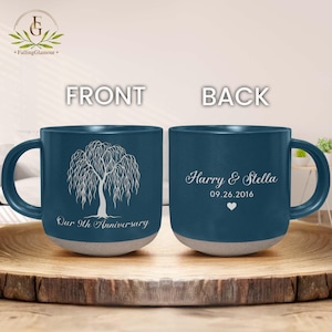 May include: A pair of blue ceramic mugs with white text and designs. One mug features a weeping willow tree and the text "Our 9th Anniversary." The other mug has the names "Harry & Stella," the date "09.26.2016," and a heart symbol.