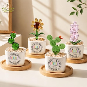 May include: Four white square ceramic planters on wooden coasters, each containing a glass plant sculpture. The planters feature the text "OFFICE squad Helen" surrounded by words like "COMPASSIONATE," "CARING," "LOVING," "KIND," "LOYAL," "FUN," "RELIABLE," "DEDICATED," and "WARM."