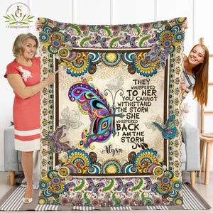 May include: A colourful throw blanket with a butterfly design and the text "They whispered to her you cannot withstand the storm she whispered back I am the storm Alysa".