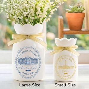 Pu&ograve; includere: Due vasi in ceramica bianca con bordi smerlati e fiocchi dorati. Il vaso pi&ugrave; grande presenta un design blu con "University of Chicago", "Amelia Taylor" e "Class of 2026". Il vaso pi&ugrave; piccolo ha un design dorato con "University of Texas", "Olivia" e "Class of 2020".
