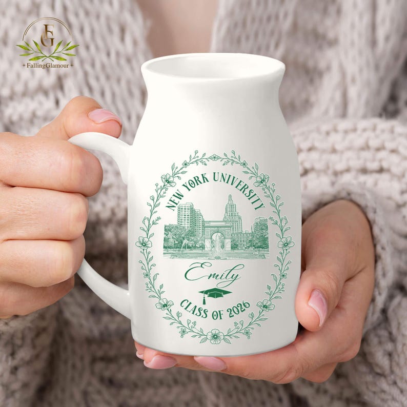 Pu&ograve; includere: Tazza in ceramica bianca con manico, con un design a ghirlanda floreale verde con il testo "New York University" e un'illustrazione dell'universit&agrave;. La tazza include anche il nome "Emily" e "Class of 2026".
