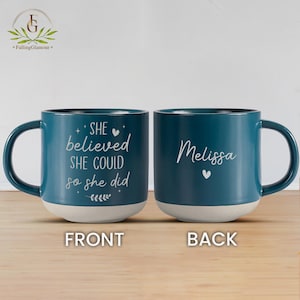 May include: Teal blue ceramic coffee mug with a white inscription on the front that reads "SHE believed SHE COULD so she did" and a white heart. The back of the mug has the name "Melissa" in white with a small white heart.