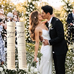 May include: A wedding celebration with a couple kissing, surrounded by falling confetti. Two confetti cannons are visible, with the words "Celebrate Love." The bride wears a white dress, and the groom is in a black suit.