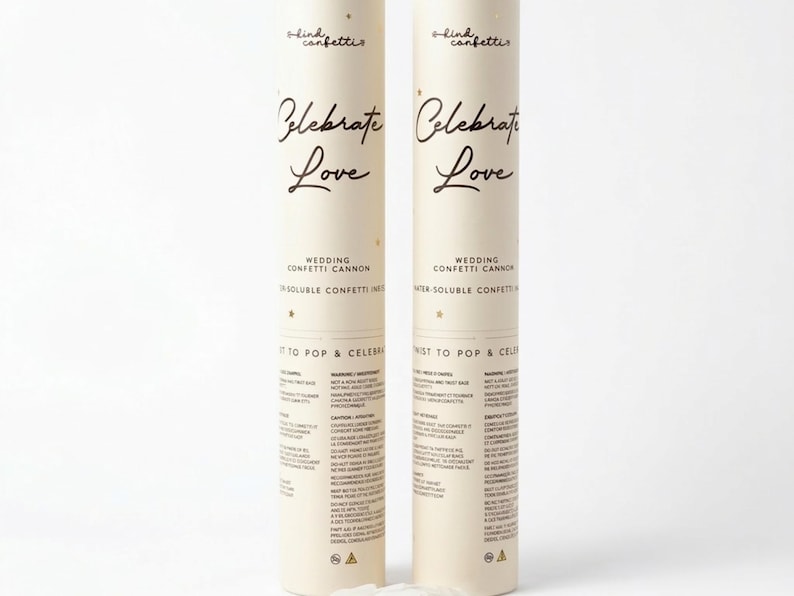 Op de afbeelding: Twee cr&egrave;mekleurige confetti-kanonnen met gouden tekst "Celebrate Love". De tekst "Wedding Confetti Cannon" en "Water-Soluble Confetti" zijn ook zichtbaar. De kanonnen zijn ontworpen voor feesten.