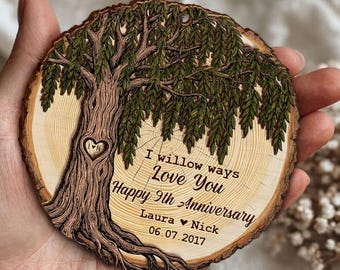 Puede incluir: Adorno circular de madera con un diseño de árbol tallado y la inscripción "I willow ways Love You Happy 9th Anniversary", junto con nombres y una fecha. El adorno tiene una veta de madera natural y un pequeño agujero para colgar.