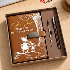 May include: A brown leather journal and pen set in a gift box. The journal features a bear and child illustration with the text "Mrs. Gerecke, Never forget the difference you make. Thank you, Jessica."