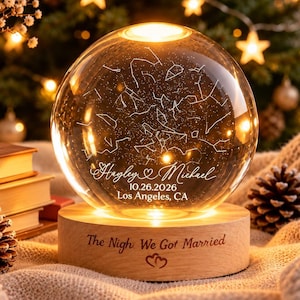May include: A clear glass sphere lamp featuring an etched star map, the names Hayley & Michael, the date 10.26.2026, and Los Angeles, CA. The sphere sits on a light wood base engraved with the text The Nigh We Got Married and two hearts.