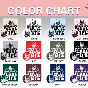 May include: Color chart showing 12 different color options for a t-shirt design. The design features a black hand with a middle finger raised, and the text "Somebody's Feral Wife". The colors include sand, white, light blue, light pink, sport grey, red, military, black, forest green, maroon, navy, and purple.