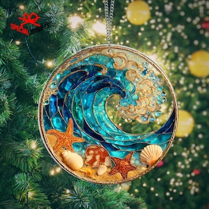 May include: Round Christmas ornament featuring a mosaic wave design in shades of blue and gold. The ornament includes starfish and seashells on a sandy base. The text "SPECIAL JOY GIFTS" is visible on the top left.