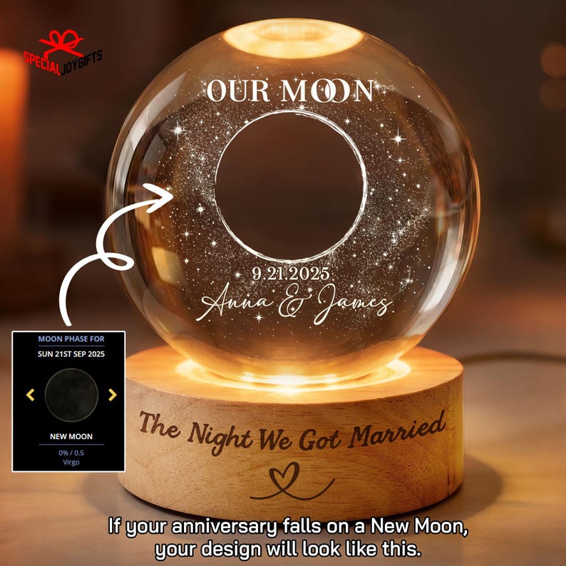 May include: A clear glass sphere lamp on a cylindrical wooden base. The sphere features the text OUR MOON, a circular graphic, the date 9.21.2025, and the names Anna & James. The wooden base is engraved with The Night We Got Married and a heart icon.
