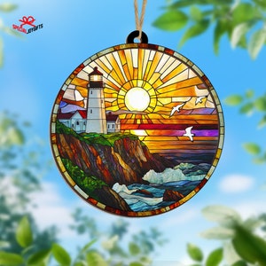 May include: A round wooden ornament with a stained glass design depicting a lighthouse on a cliff overlooking a stormy sea with a bright sun and birds flying overhead.