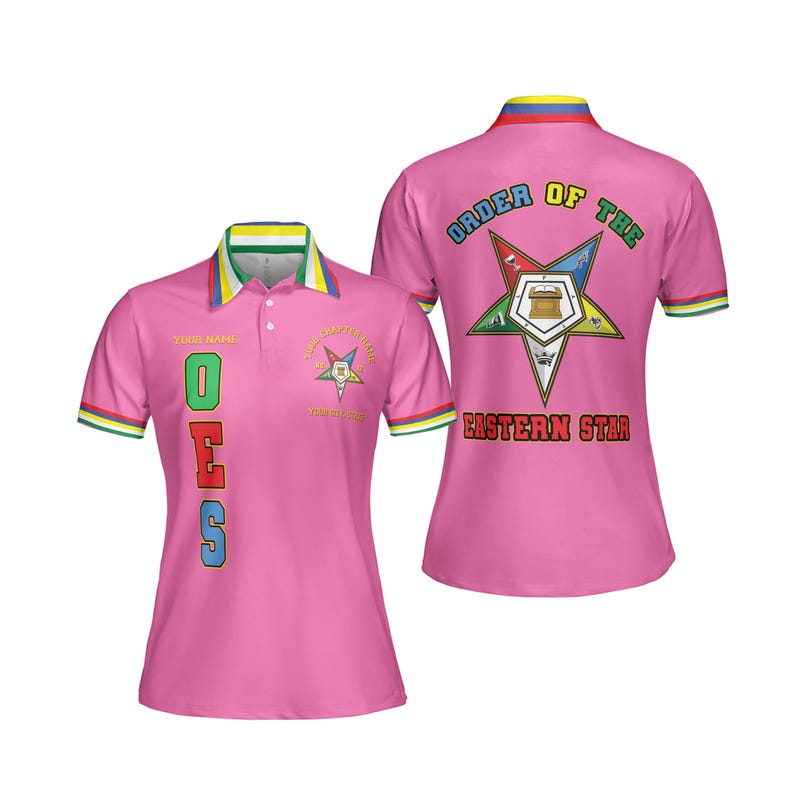Puede incluir: Polo rosa con el texto "OES" en letras coloridas en la parte delantera. La camisa tiene un cuello y ribetes de manga con rayas verdes, amarillas y azules. La parte trasera de la camisa muestra las palabras "ORDER OF THE EASTERN STAR" y un emblema de estrella.