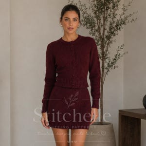 Peut inclure: Un ensemble deux pièces en tricot bordeaux foncé composé d'un cardigan à manches longues boutonné et d'une jupe courte assortie. L'ensemble présente un motif en tricot texturé, un col rond, des poignets et un ourlet côtelés. Le texte Stitchery Knitting Patterns est visible.