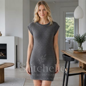 Könnte beinhalten: Ein anthrazitfarbenes Strickkleid mit Rundhalsausschnitt, kurzen Ärmeln und einem gerippten Saum. Das Kleidungsstück hat eine glatte, gleichmäßige Textur am gesamten Körper und ist mit einem dezenten Blumenlogo und dem Text "Stitchelle" versehen.