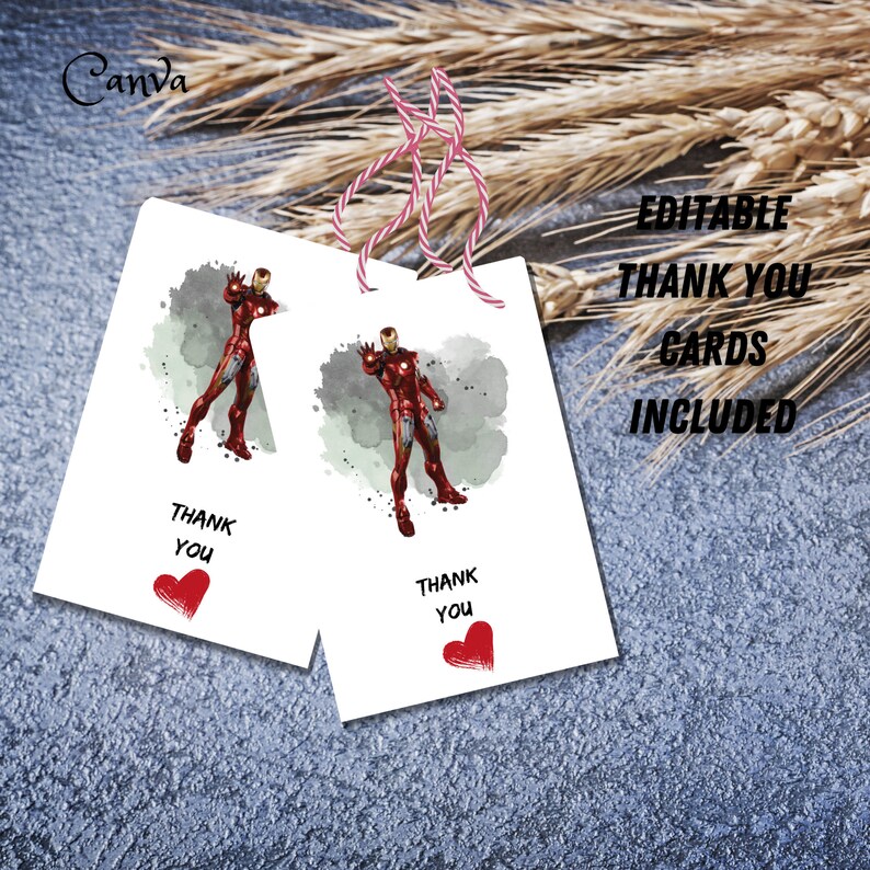 Puede incluir: Dos tarjetas de agradecimiento blancas con ilustraciones de Iron Man. Cada tarjeta tiene las palabras "THANK YOU" y un coraz&oacute;n rojo. Las tarjetas est&aacute;n atadas con hilo rosa y blanco. El texto "EDITABLE THANK YOU CARDS INCLUDED" tambi&eacute;n es visible.