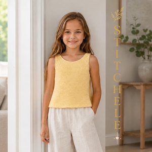 Può includere: Un top smanicato in maglia gialla con scollo rotondo e un motivo a maglia testurizzato, abbinato a pantaloni di colore chiaro. L'immagine include il testo verticale STITCHELLE in un carattere dorato sul lato destro della cornice.