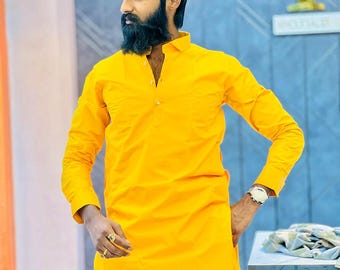 Op de afbeelding: Een man draagt een felgele, langarmige kurta met een knoopsluiting. De kurta is een traditioneel Indiaas kledingstuk.