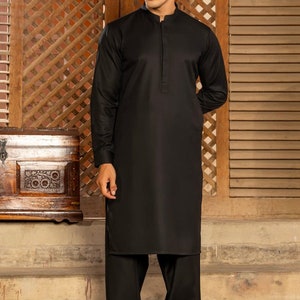 May include: A black long-sleeved shirt with a mandarin collar and a button closure. The shirt is paired with black pants and black shoes.