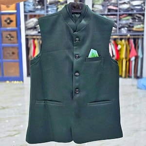 May include: A dark green sleeveless waistcoat with a mandarin collar and five black buttons. The waistcoat has two pockets and a pocket square.